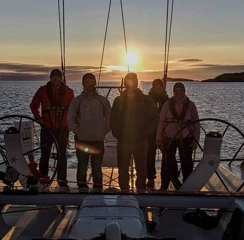 Crew aboard a yacht at sunset