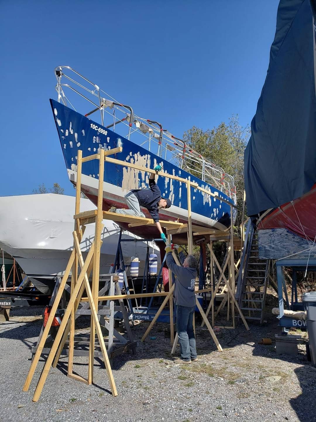 Mr Jumpa up on stands, crew prepping the hull during restoration